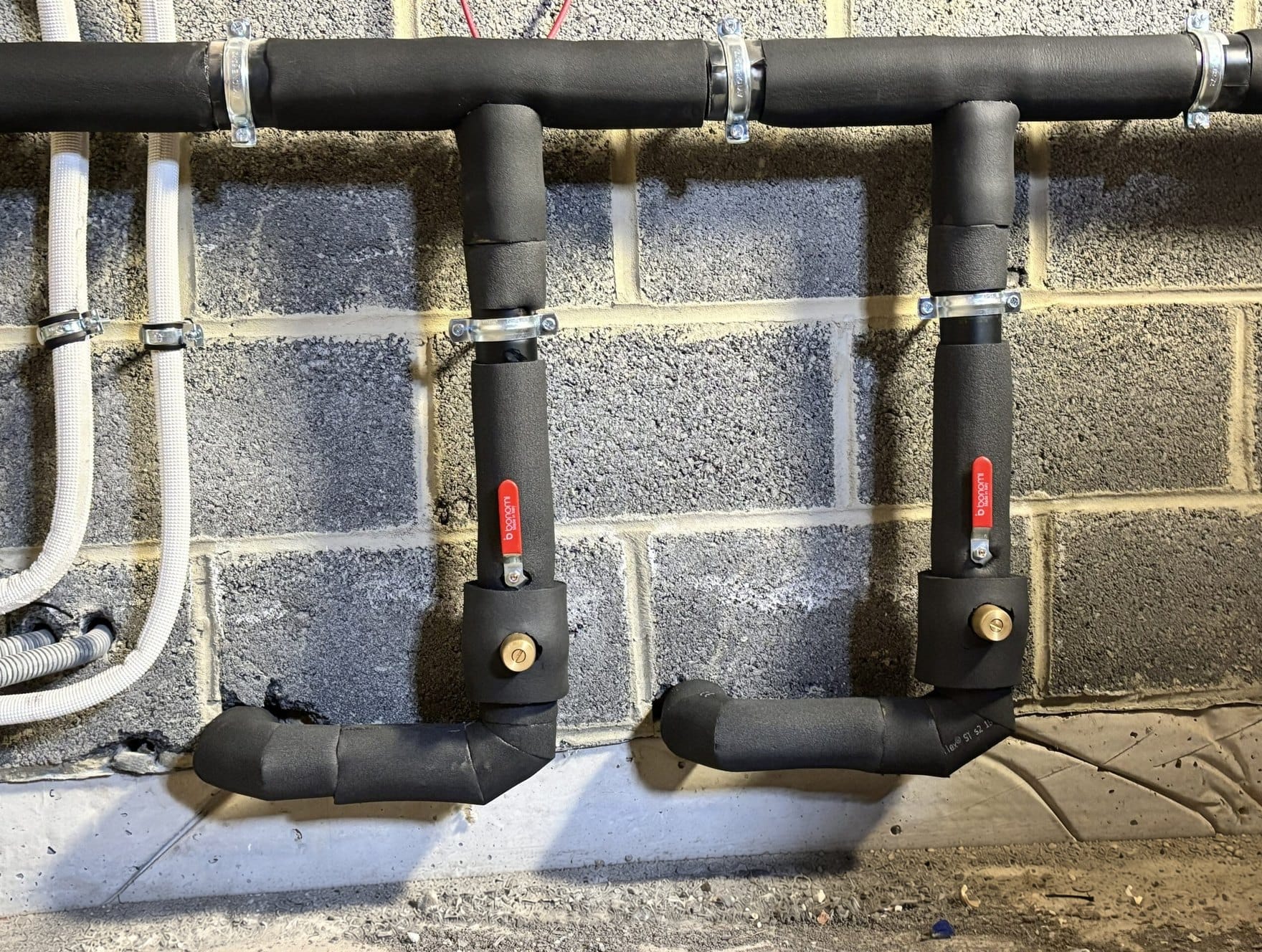 Arrivée d'eau froide SWDE protégée du gel (Armaflex 19 mm + câble chauffant) dans une grange à Fernelmont